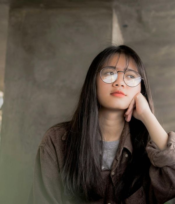Thoughtful person contemplating in a calm, modern setting.